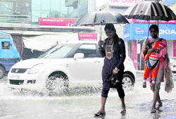Two girls walk on a flooded road in Dehradun on Wednesday