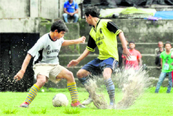 A match in the Lala Nemi Dass Memorial District Football League under way in the rain in Dehradun on Wednesday