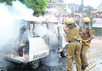 Police and fire brigade personnel put out the fire which engulfed a van in Mandi on Wednesday. 