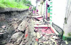 A boundary wall that collapsed in an area on the Sahastradhara road following heavy rain in Dehradun on Thursday.