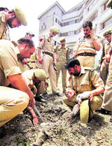 Police personnel examine the spot where an IED was defused near the Dal Lake in Srinagar on Thursday.