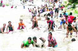 Villagers catch fish during the annual Maund festival in the Aglar river in Tehri Garhwal on Friday