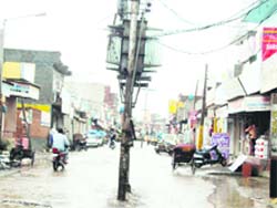 Electricity poles in the middle of the Old Sabzi Mandi Road in Jagraon.
