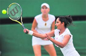 Sania Mirza (R) and Elena Vesnina in action against Kveta Peschke and Katarina Srebotnik during their semifinal in Wimbledon on Friday