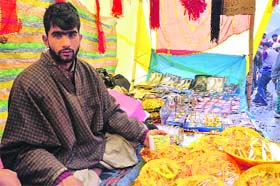 A shopkeeper, belonging to the majority community, sells pooja samagri ouside the Amarnath cave shrine