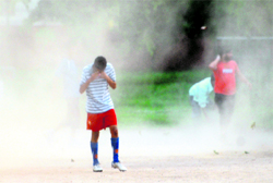 A boy covers his face during a dust storm in Sector 20, Chandigarh, on Sunday