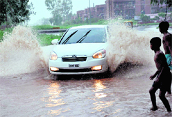 A car makes its way through a waterlogged road in Chandigarh