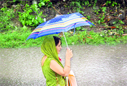 A woman walks in the rain in Jammu on Sunday