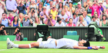 Novak Djokovic lies on the ground after beating Rafael Nadal in the men's single final at Wimbledon on Sunday. Djokovic won 6-4, 6-1, 1-6, 6-3.  AFP