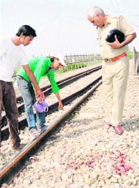 A police official investigates the spot where a labourer was crushed to death by a train on Monday