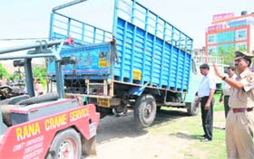 The enforcement staff of the MC lift a truck during an anti-encroachment drive at Burail village on Monday