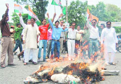 Congress workers burn an effigy of the BJP government for allegedly tarnishing the image of Leader of the Opposition Harak Singh Rawat at Niranjanpur Mandi 