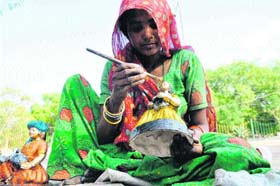 A woman gives finishing touches to a puppet in Gurgaon