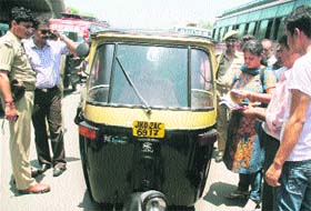 Officials of the Weight and Measures Department along with the police check the meter of an autorickshaw in Jammu on Monday