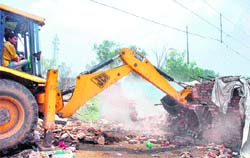 A JCB machine demolishes encroachments during a drive carried out by the UT administrationat Sector 26, Chandigarh