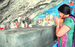 A woman pilgrim prays outside the Amarnath cave shrine on Tuesday