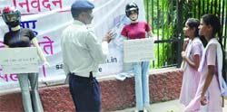 A Delhi traffic police constable educates schoolgirls about the importance of wearing helmet in New Delhi