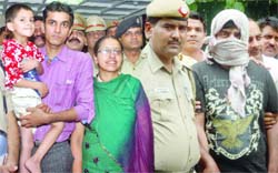 Accused Milind Godi (right) is arrested for the kidnapping of 5-year-old Ram Arora who is seen with his parents, in New Delhi 
