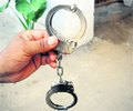 A cop shows imported handcuffs at Mandi Ahmedgarh