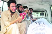 Relatives of a person killed in the violence mourn over his death inside an ambulance at the Jinnah Postgraduate Medical Centre in Karachi on Wednesday. 