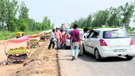 Fruit sellers create traffic hazards on the National Highway No.1 between Karnal and Taraouri