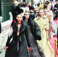Models for designer Jean-Paul Gaultier walk outside on a red carpet after his Haute Couture Fall-Winter 2011/2012 fashion show in Paris. 