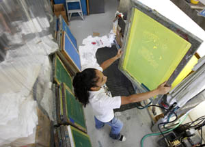 Printers assistant Rosa Ross prepares a stencil for custom T-shirts at Space Shirts in Merritt Island, Florida