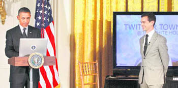 Barack Obama sends a tweet as Twitter co-founder Jack Dorsey looks on during a Twitter Town Hall in Washington 