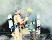Firefighters try to ventilate smoke billowing from the fire in the basement of a shop in Sector 22, Chandigarh. 