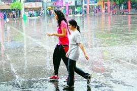 Girls walk in the rain at the Sector 17 market in Chandigarh on Friday.