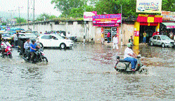 Vehicles move through a water-logged road at Dogra Chowk in Jammu on Friday