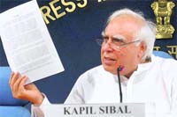 Communications and IT Minister Kapil Sibal shows a document while addressing the press in New Delhi