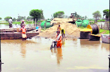 Residents of Mohar Jamsher village, located near the Radcliffe Line, wade through water