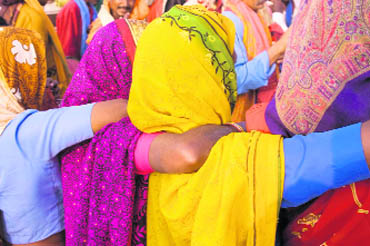 Women of Chhattisgarh wrap their arms around one another during a harvest dance. Huyler has used this picture as a cover for his book Daughters of India 