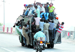 A private bus bursting at its seams, indicating the enormity of the burgeoning population on the eve of the World Population Day in Bathinda