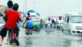Vehicles drive through a waterlogged road near Seelampur Metro station in New Delhi on Sunday.