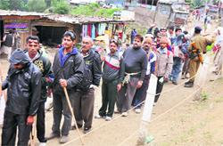 Pilgrims stand in a queue for a security check at Chandanwari on the way to the Amarnath cave shrine on Sunday