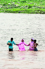 Residents cross the Darhali nullah at Muradpur in Rajouri district on Saturday