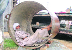 An elderly man catches his breath in an iron pipe used for boring in Ludhiana