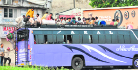 Passengers sit atop an overloaded bus in Ludhiana