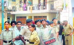 A team from the Chandigarh police looks on as municipal corporations enforcement staff carry out a demolition drive at Kajehri village 