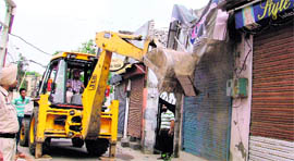 A JCB machine demolishes illegal structures on Nihal Singh road.