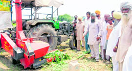 Villagers show the fodder-cutting machine.