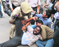 A policeman scuffles with student demonstrators at 