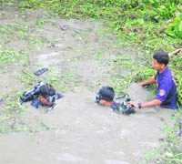 Scuba drivers search for bodies in a water-filled ditch in Mirershorai, 200 km from Chittagong, on Monday. 