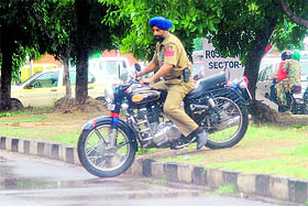 A policeman riding an official motor cycle violates the traffic rules by crossing the median near Rose Garden, Sector 10/16, Chandigarh.