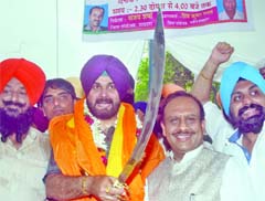 Appointed co-incharge of election for the party, Navjot Singh Sidhu with Delhi Pradesh BJP president Vijender Gupta brandishes a sword during a joint press conference in New Delhi