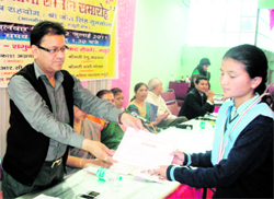 Mussoorie Municipal Council President OP Uniyal presents a certificate to a meritorious student in Mussoorie on Tuesday