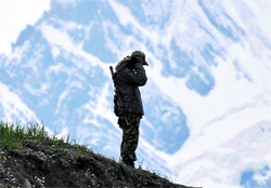 A CRPF jawan stands guard on the Baltal route to the Amarnath cave shrine near the Sangam camp
