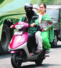 Three women ride a scooter in Jammu on Tuesday